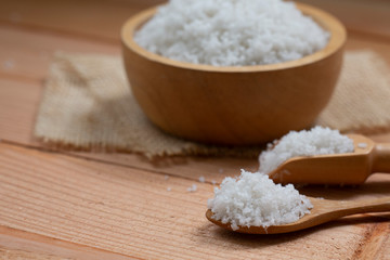 sea salt on wooden spoon on wood table.