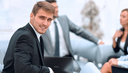 successful handsome businessman sitting at a work Desk on blurred background