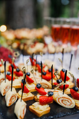 on a wooden table in the wedding banquet area are snacks, fruits, sweet cakes and muffins and lemonade drink
