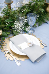 banquet table is decorated with plates, cutlery, glasses, candles and flower arrangements