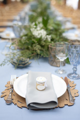 banquet table is decorated with plates, cutlery, glasses, candles and flower arrangements