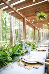 banquet table is decorated with plates, cutlery, glasses, candles and flower arrangements