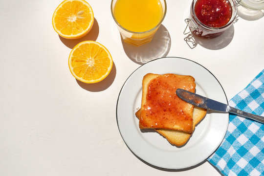 Bread toast with orange juice and jam on white background