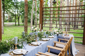 banquet table is decorated with plates, cutlery, glasses, candles and flower arrangements