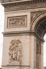 Fototapeta na wymiar Architectural fragment of Arc de Triomphe. Arc de Triomphe de l'Etoile on Charles de Gaulle Place is one of the most famous monuments in Paris.
