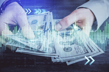 Multi exposure of financial graph drawing hologram and USA dollars bills and man hands. Analysis concept.