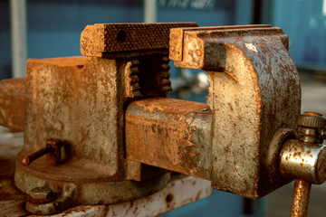 Old rusty vise for working, securing by tightening and machining metal and parts