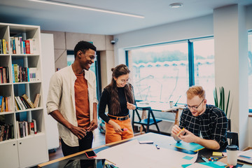 Diverse cheerful colleagues creating ideas for project