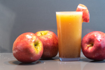 Apple juice and fresh fruits on light background