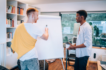 Obraz premium Young man explaining data for black colleague