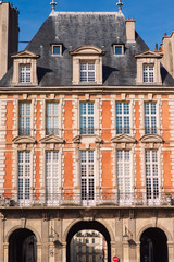 Fototapeta premium Typical building at Place des Vosges known as Place Royale - oldest planned square in Paris, in Marais district. Place des Vosges built by Henri IV from 1605 to 1612. Paris