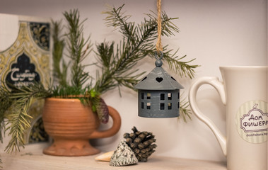 lamp on a pine twig next to a mug on a dish rack