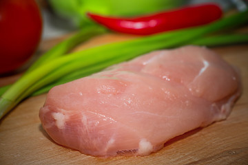 Closeup chicken fillet with vegetables on a cutting board