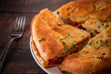 A piece of cake with chicken, herbs and tomatoes on a plate. Homemade delicious food for diet.