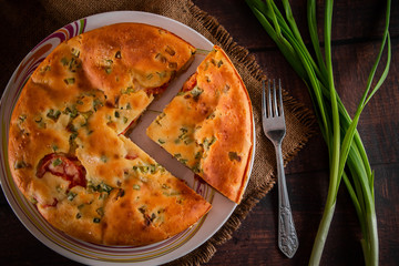 Delicious homemade pie with chicken, herbs and tomatoes on a plate.