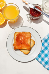 Bread toast with orange juice and jam on white background