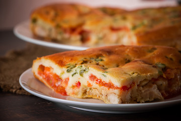 A piece of cake with chicken, herbs and tomatoes on a plate. Homemade delicious food for diet.