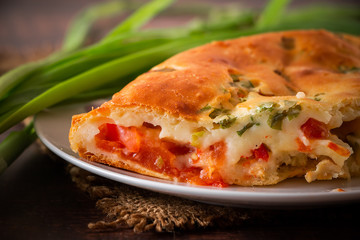 A piece of cake with chicken, herbs and tomatoes on a plate. Homemade delicious food for diet.