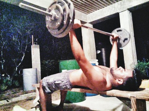 Shirtless Man Performing Bench Press At Home