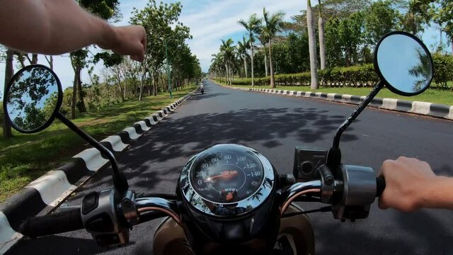 .Riding a motorcycle on a paved road in the first person