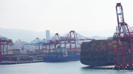 bright multi-colored containers on huge cargo barges in an industrial port. Large container ships in the cargo terminal of the port are moored at loading unloading. worldwide shipping