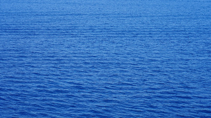 Fototapeta na wymiar small waves on the surface of the ocean, the texture of calm clear water in the Pacific Ocean of incredible color. turquoise blue sea water. wavy surface. sun reflection