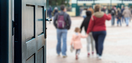 Opened door concept with a family of tourists going to amusement park