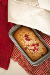 sweet raspberry bread freshly baked in a loaf pan with dish towels