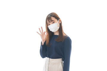 マスクを装着してOKサインをする若い女性