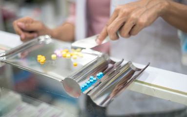 Female pharmacist preparing medicine capsule pack pharmacy to sell to patient for protect coronavirus,