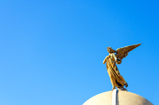 Low Angle View Of Angel Statue At La Recoleta Cemetery Against Clear Blue Sky