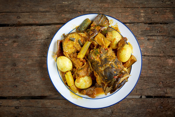 Tasty fish curry cooked in coconut milk on wooden table