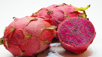 Colorful juicy dragon fruit on a white background. tropical fruit close, cut of purple pitahaya...