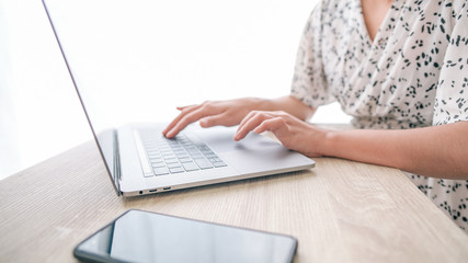 Fototapeta premium Close up low angle view of Woman in quarantine for Coronavirus wearing protective mask and smart working Hands holding credit card and using laptop. Online shopping