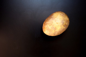 Obraz na płótnie Canvas Potato on black table, food background