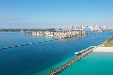 Government Cut jetties and Fisher Island on clear sunny morning with City of Miami skyline in background.