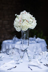 elegant white flowers and candles arranged on table for wedding event