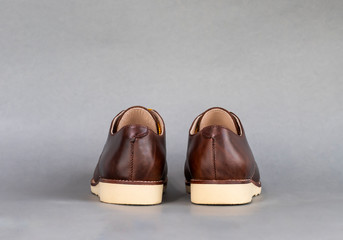 Men fashion brown shoe leather over gray background.
