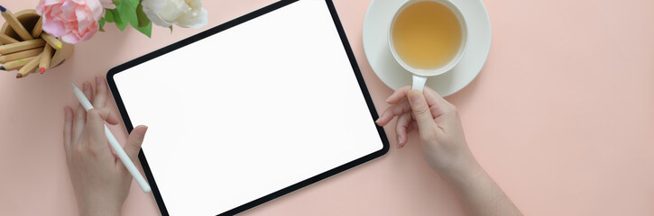 Overhead shot of female university student doing homework with blank screen tablet