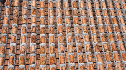 Traditional Japan Okinawa clay tiles texture. old brown handmade roof tiles on a sunny day