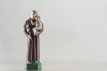 Image of Catholic saints where Saint Anthony appears with Jesus on his lap on a light background