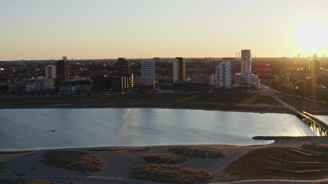 Golden sunset at beach park with city skyline and bridge from aerial drone view