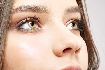 Obraz premium Closeup macro portrait of female face with pink lips and smoky eyes beauty makeup.