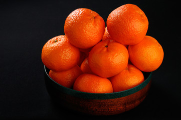 Spanish Clementine Mandarin Oranges in a Mahogany wood bowl on black
