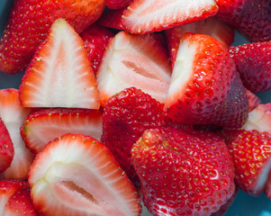 Close up view of ripe strawberries sliced and sitting in a blue bowl