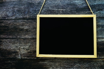 Empty black board on dark wooden wall texture background