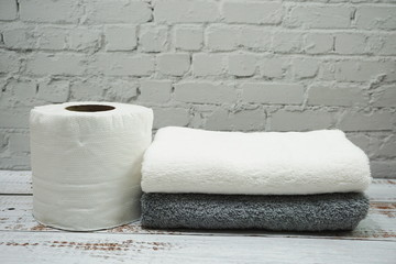 Clean Towel and Tissue roll paper with space copy on wooden background