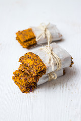 Crunchy crispy breads or flax seeds flatbreads in parchment baking paper with thread. Vegan food.