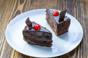 two chocolate cakes with cherries on a white plate