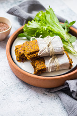 Crunchy crispy breads or flax seeds flatbreads on plate with green salad leaves. Vegan dieting food.